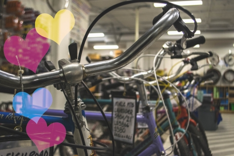 A picture of colourful bikes lined up with hearts on the left side of the image.